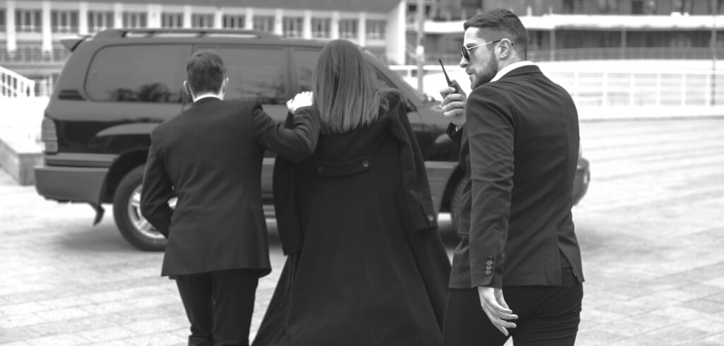 Trojan Investigations and Security close protection experts and body guards escorting a client to a waiting vehicle